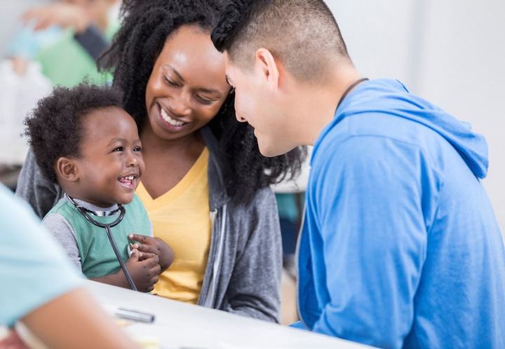 A young family meeting with a caseworker across a table.